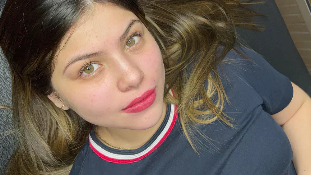 Young woman with blonde hair and red lipstick representing modern tattoo enthusiasts seeking arm tattoo inspiration.