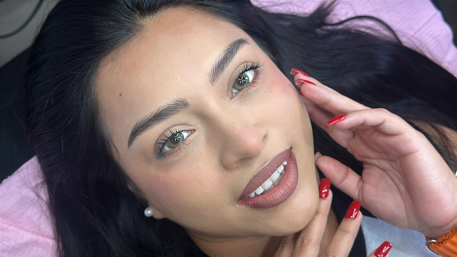 Happy woman showcasing fresh microblading eyebrows results during initial healing phase consultation appointment.