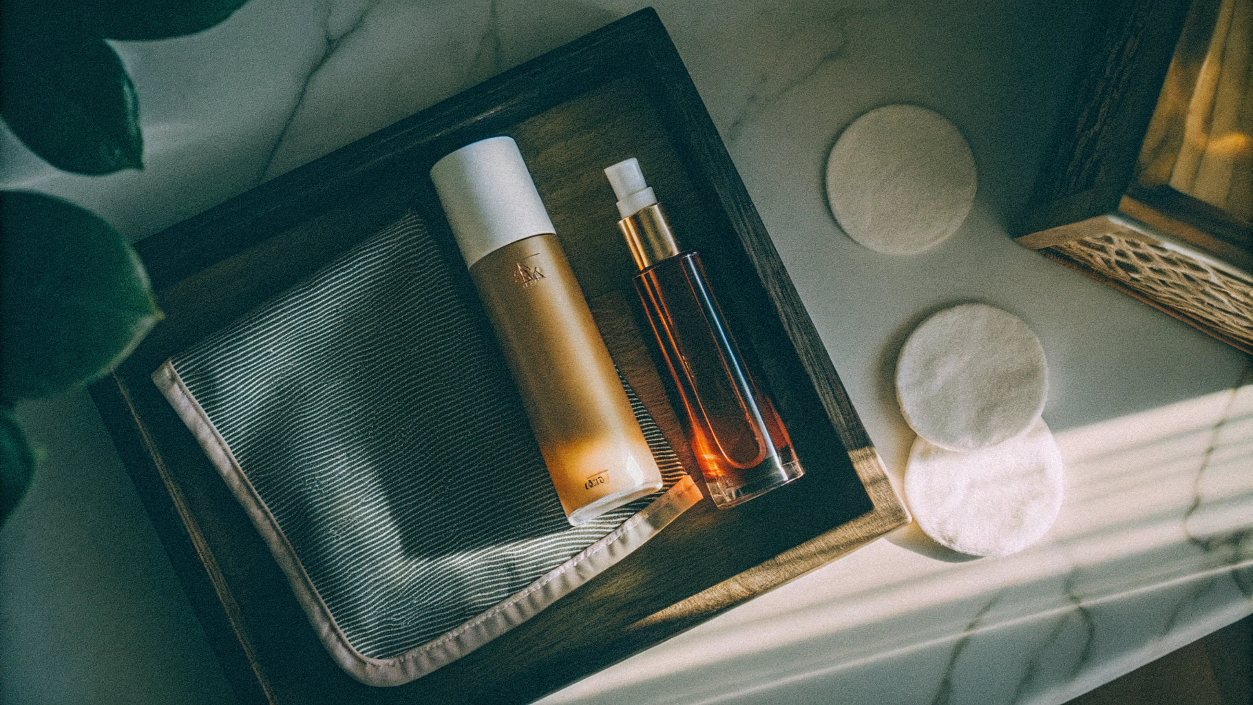 Beauty products for skincare and eyeliner application on elegant wooden tray.