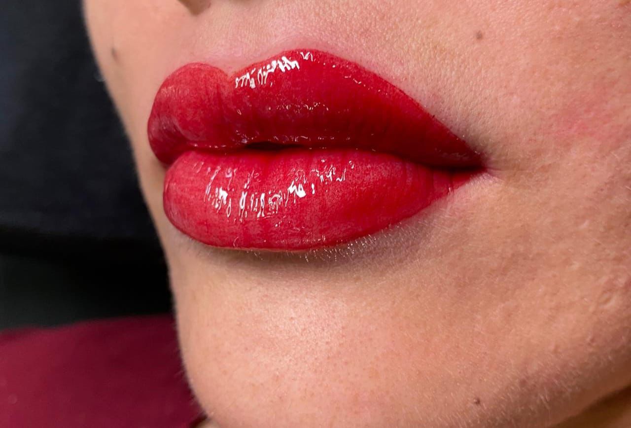 Vibrant red Lip Blush treatment with glossy finish enhancing natural lip shape.