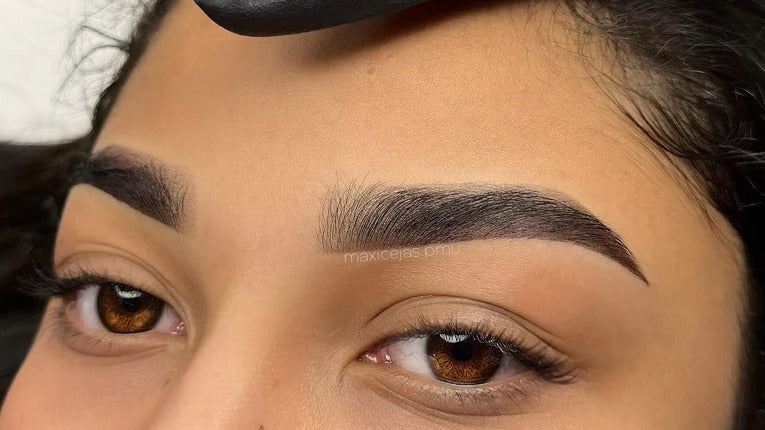Close-up of perfectly shaped eyebrows showing natural-looking permanent eyeliner correction that enhances the eye without appearing overly tattooed.