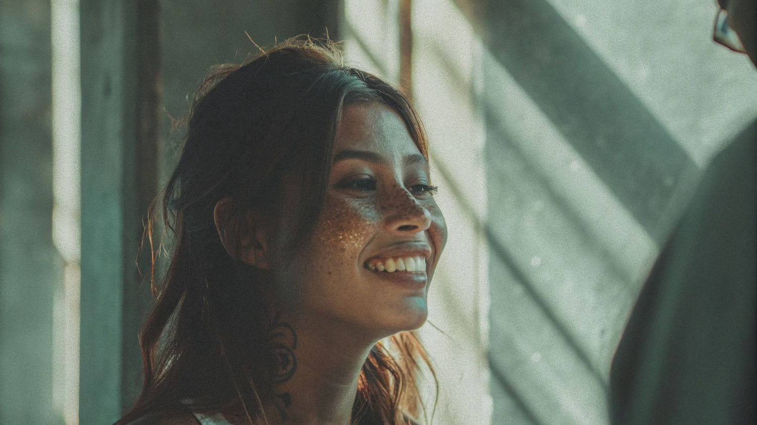 Natural-looking beauty mark and freckle tattoos enhancing facial features in soft sunlight