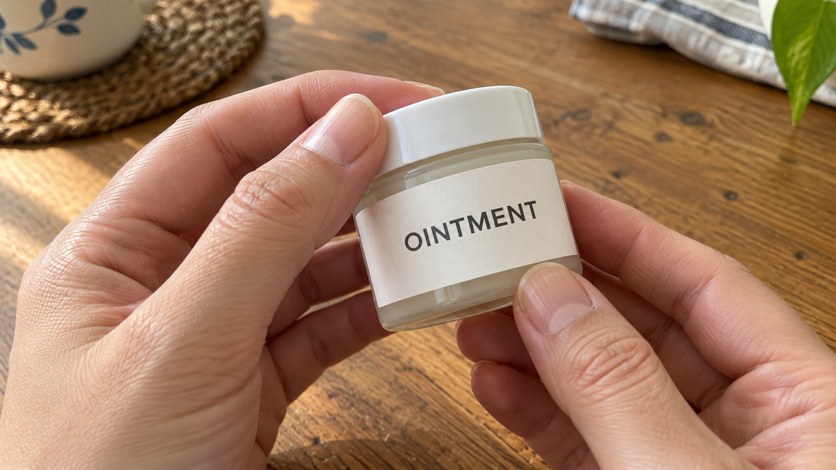 Hands turning a generic ointment jar to check its label